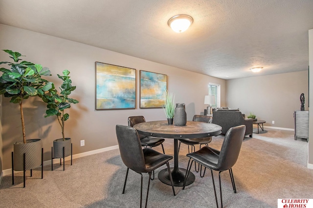 dining area with a textured ceiling and carpet flooring