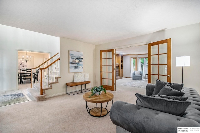 living room featuring an inviting chandelier, light carpet, and french doors