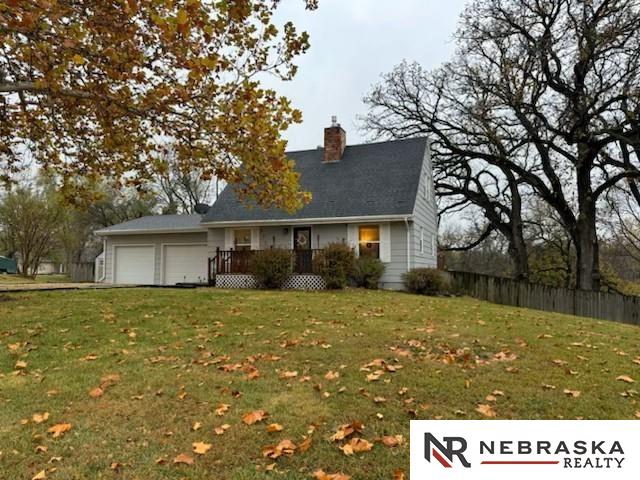 view of front of house featuring a wooden deck, a front yard, and a garage