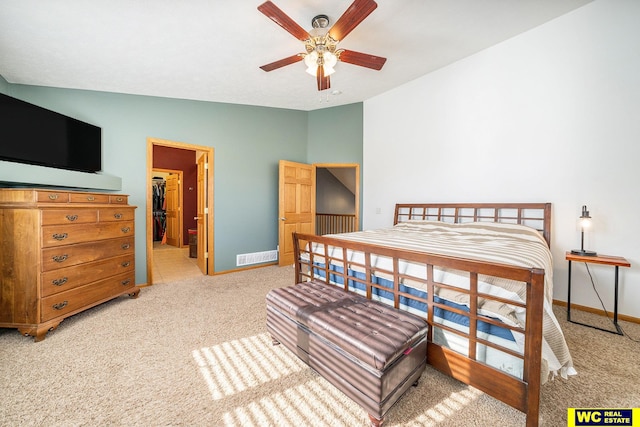 bedroom with a walk in closet, light carpet, ceiling fan, and vaulted ceiling