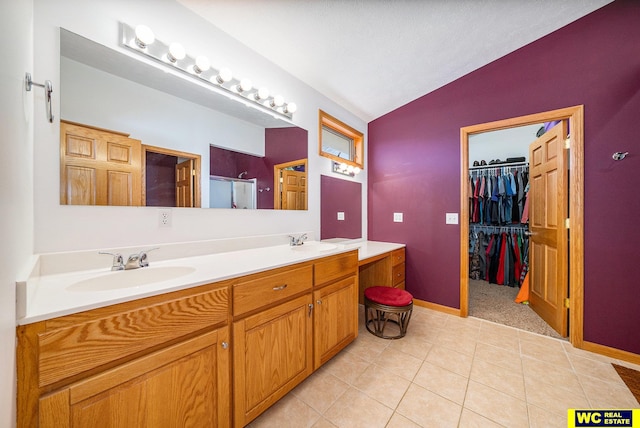 bathroom featuring tile patterned floors, walk in shower, vanity, a textured ceiling, and lofted ceiling