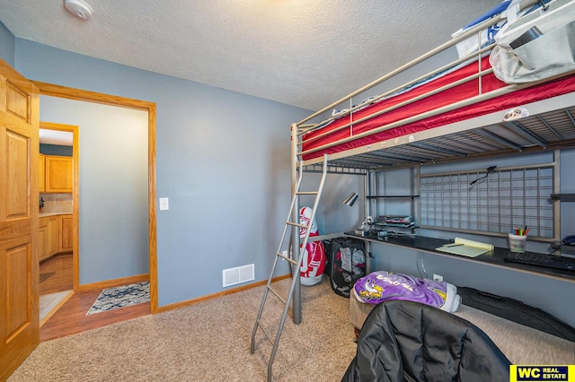 bedroom featuring carpet and a textured ceiling