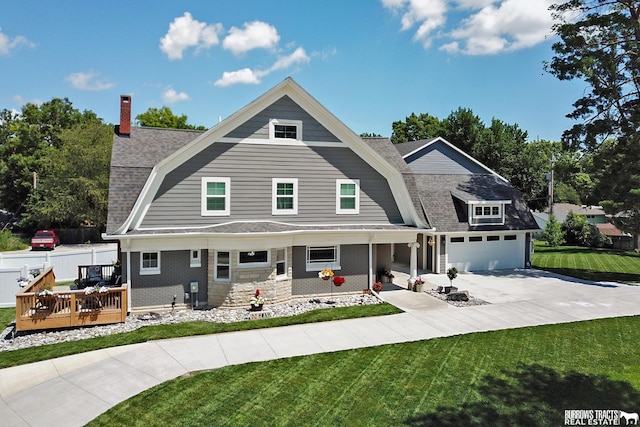 view of front of house with a front yard, a wooden deck, and a garage