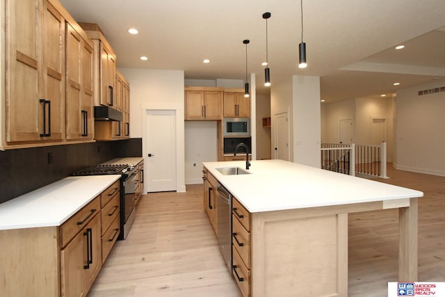 kitchen with a spacious island, light wood-type flooring, stainless steel appliances, and hanging light fixtures