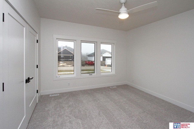 unfurnished room featuring light colored carpet and ceiling fan