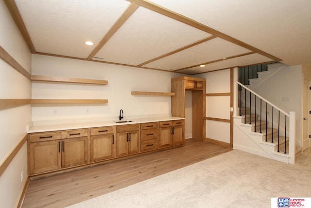 bar with light hardwood / wood-style floors, a textured ceiling, and sink