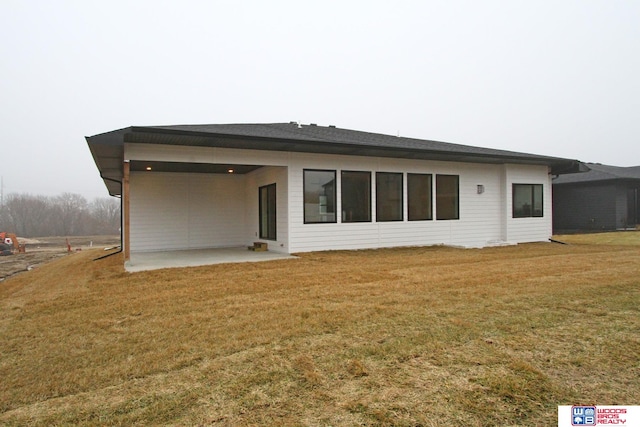 rear view of house with a patio and a yard