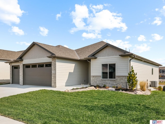 view of front of home featuring central air condition unit, a garage, and a front lawn