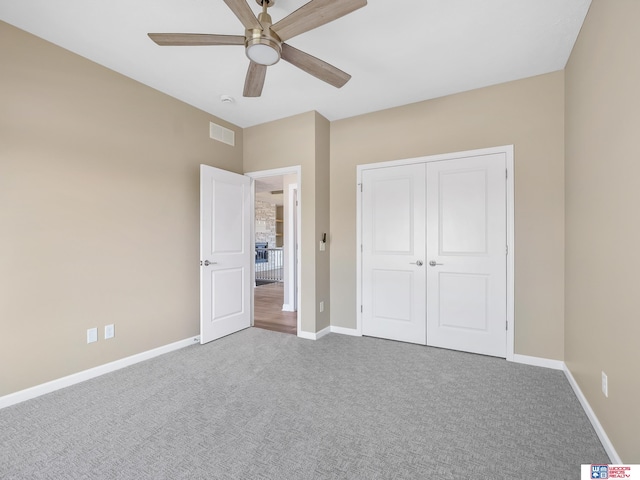 unfurnished bedroom featuring carpet, ceiling fan, and a closet