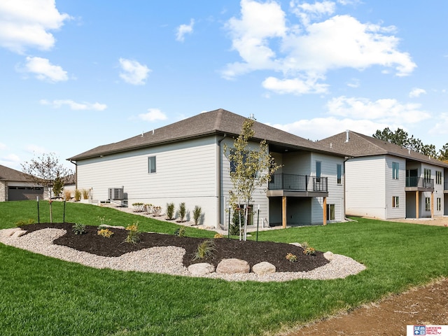 back of house with a balcony and a yard