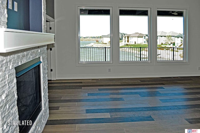 unfurnished living room featuring dark wood-type flooring and a water view