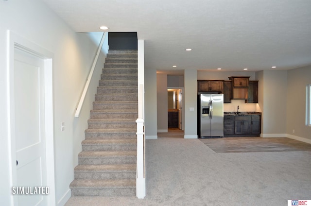 staircase with sink and carpet floors