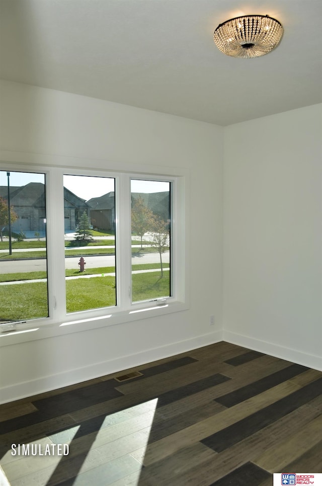 empty room with plenty of natural light and dark hardwood / wood-style flooring