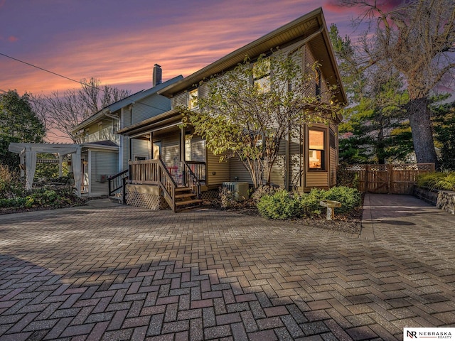 view of front of property with a pergola, covered porch, and central air condition unit