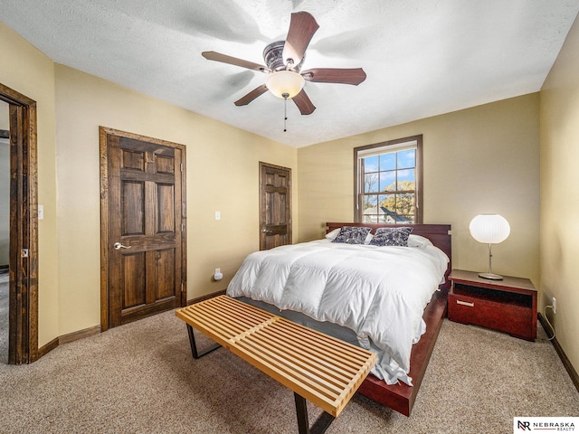 carpeted bedroom with a textured ceiling and ceiling fan