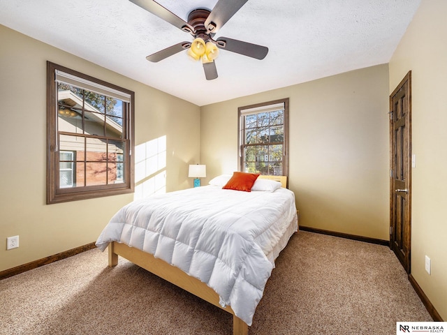 bedroom with a textured ceiling, ceiling fan, and carpet