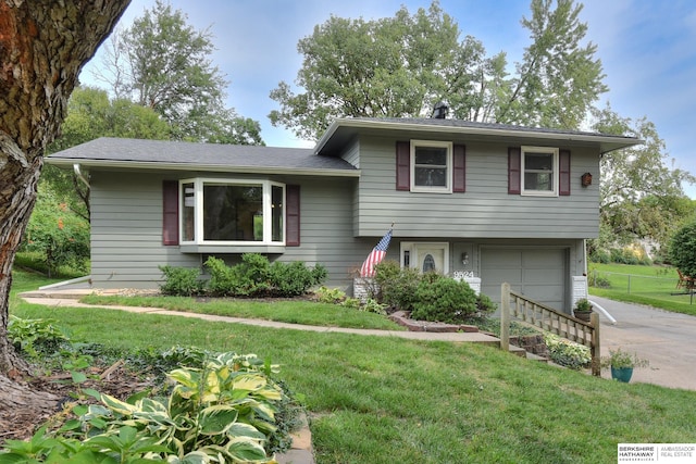 split level home featuring a garage and a front lawn