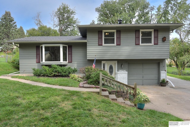 split level home with a front lawn and a garage