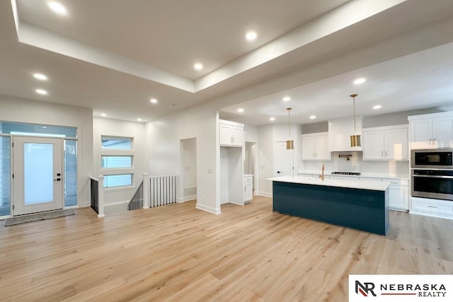 kitchen featuring white cabinets, stainless steel appliances, and light hardwood / wood-style floors