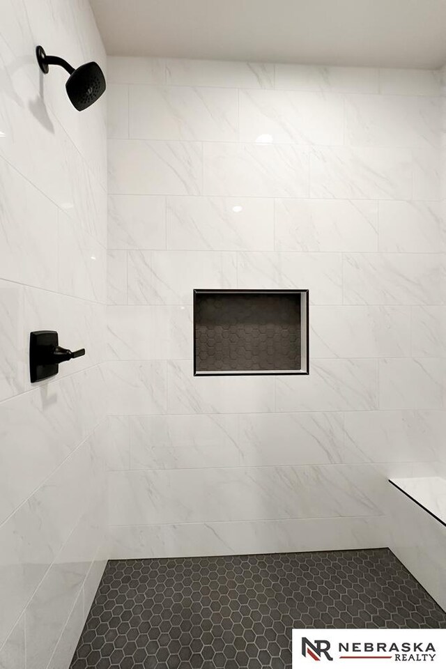 interior details featuring a tile shower