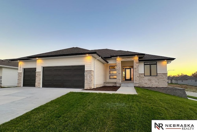 prairie-style home featuring a yard and a garage