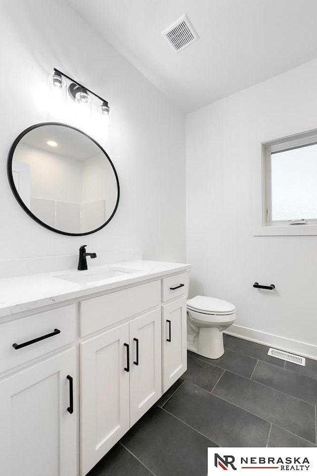 bathroom featuring toilet, vanity, and tile patterned floors