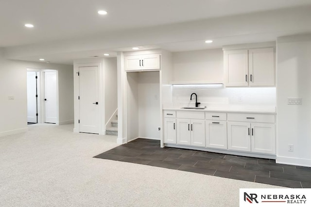 washroom with sink and dark colored carpet