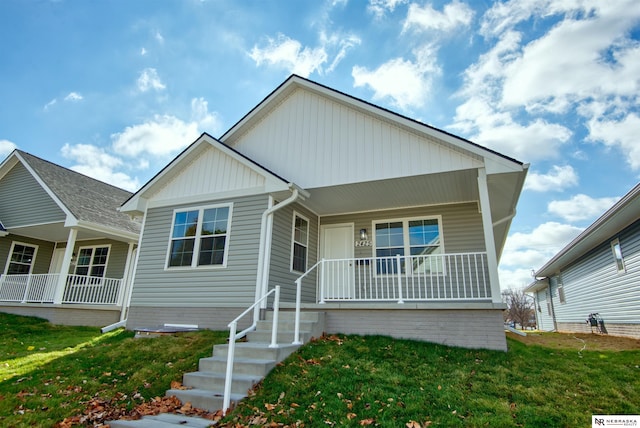 view of front facade featuring covered porch and a front yard