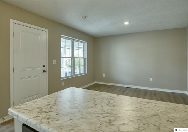 interior space featuring light hardwood / wood-style floors and a textured ceiling