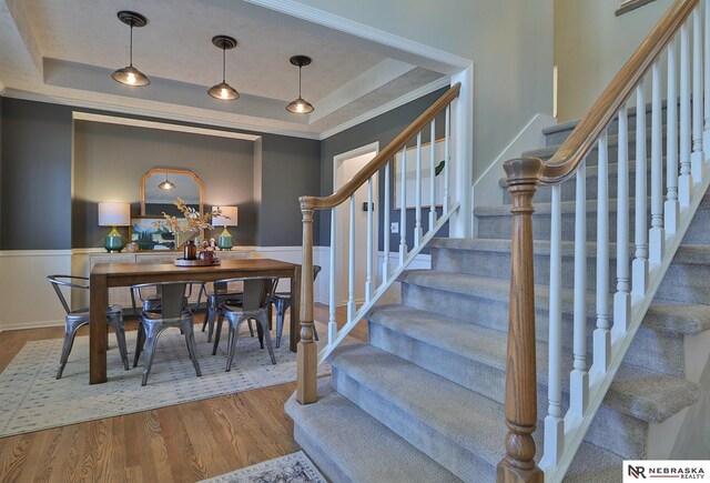 stairway featuring hardwood / wood-style flooring and a raised ceiling