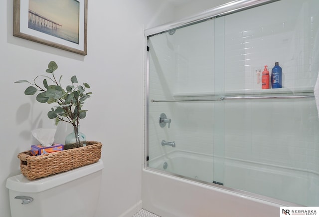 bathroom with toilet and bath / shower combo with glass door