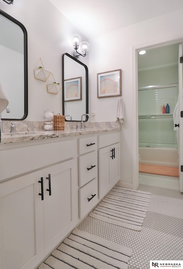 bathroom featuring vanity, tile patterned floors, and combined bath / shower with glass door