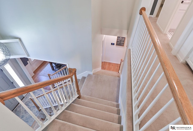 stairs with carpet and a high ceiling