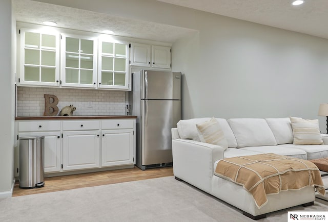 living room with light wood-type flooring and a textured ceiling