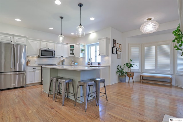 kitchen featuring light hardwood / wood-style flooring, white cabinets, and stainless steel appliances