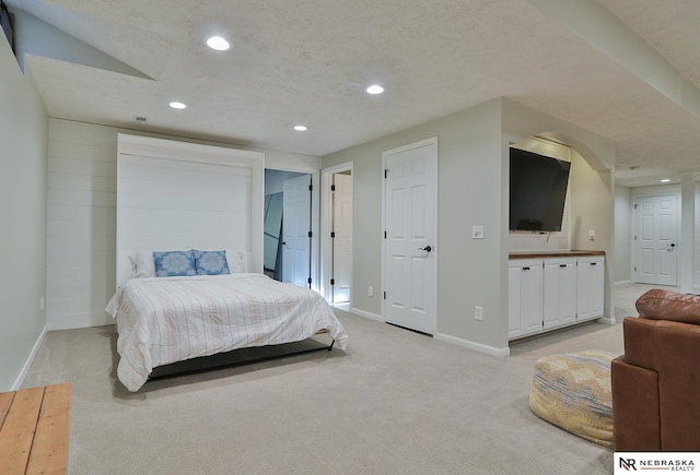 carpeted bedroom featuring connected bathroom and a textured ceiling