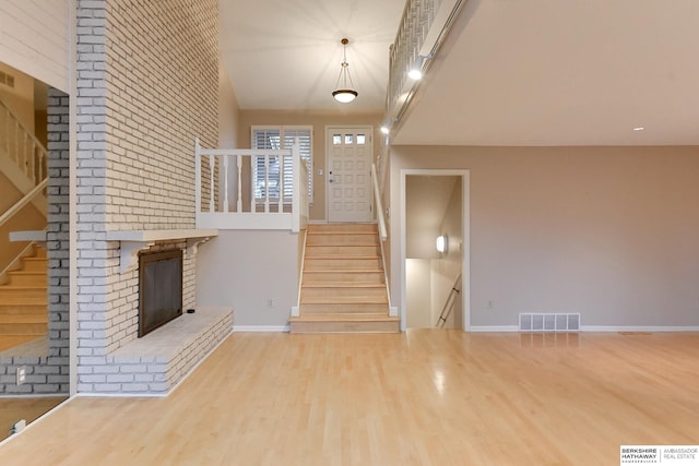 entryway featuring a brick fireplace and wood-type flooring