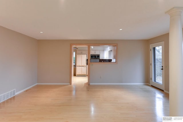 unfurnished living room with light hardwood / wood-style floors and ornate columns