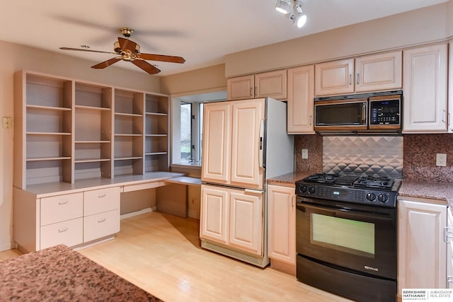 kitchen featuring black range with gas cooktop, built in desk, light hardwood / wood-style flooring, paneled fridge, and decorative backsplash