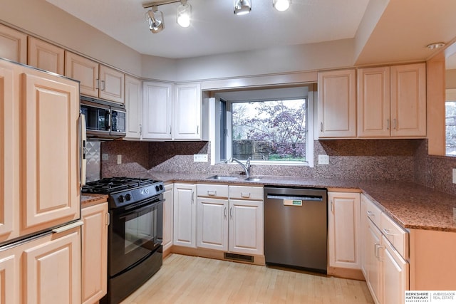 kitchen with sink, light wood-type flooring, black range with gas stovetop, dishwasher, and backsplash