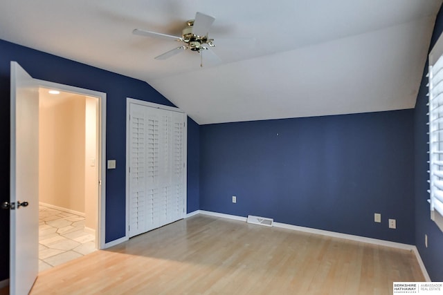 unfurnished bedroom featuring ceiling fan, vaulted ceiling, and light hardwood / wood-style flooring