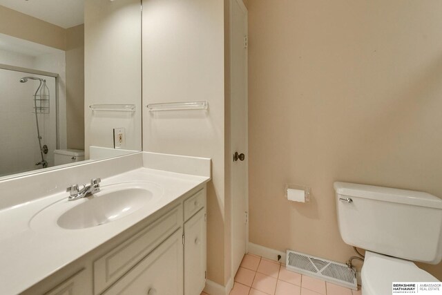 bathroom with vanity, tiled shower, tile patterned floors, and toilet