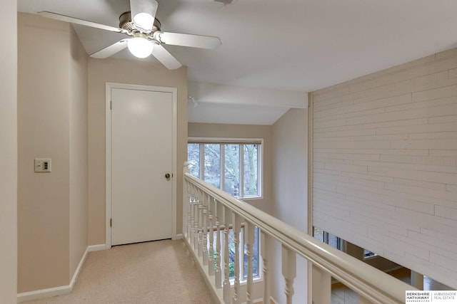 hall featuring light colored carpet and lofted ceiling