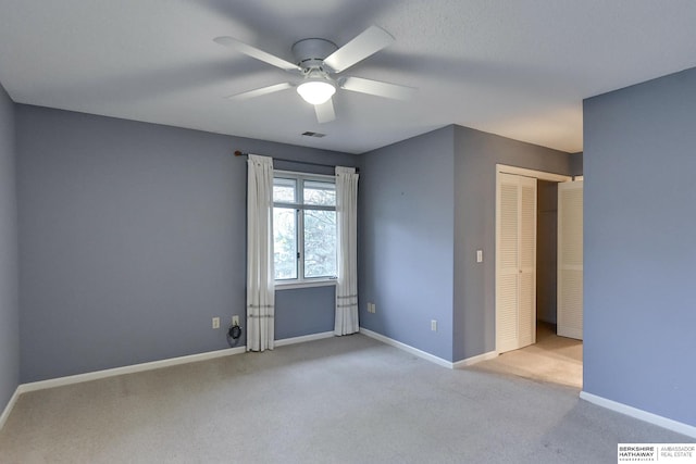 spare room featuring ceiling fan and light carpet