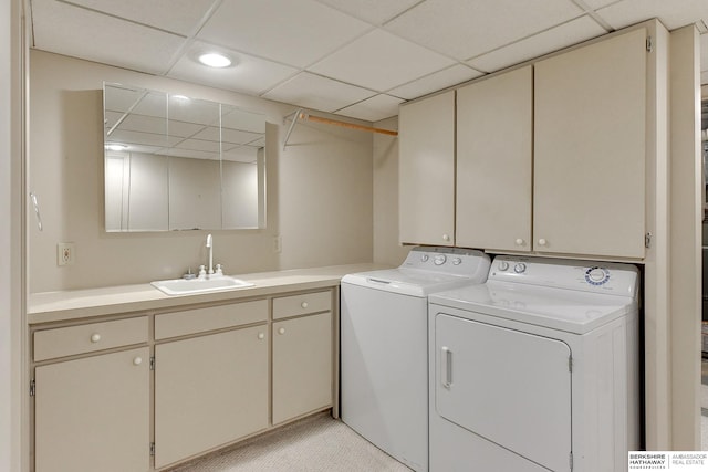 laundry area with cabinets, washer and clothes dryer, and sink