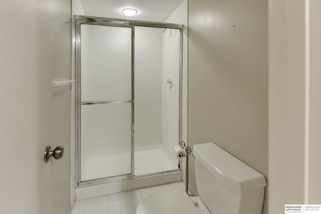 bathroom with an enclosed shower, tile patterned flooring, and toilet