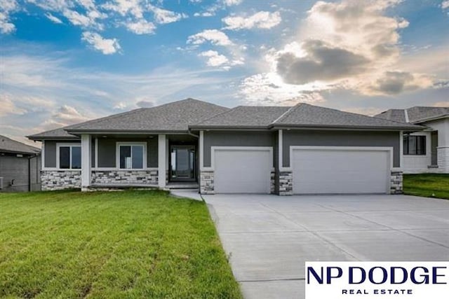 prairie-style house featuring a lawn and a garage