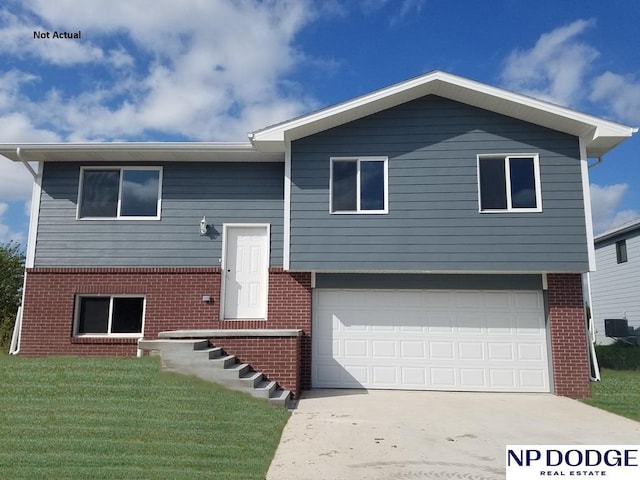 bi-level home featuring a garage and a front lawn