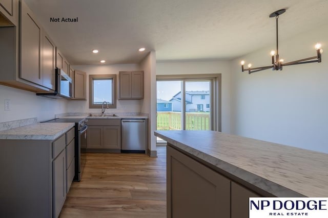 kitchen with light wood-type flooring, gray cabinetry, stainless steel appliances, decorative light fixtures, and a chandelier