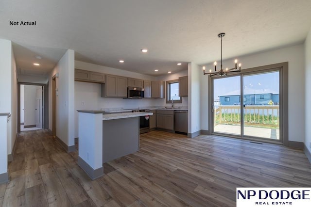 kitchen with pendant lighting, stainless steel appliances, an inviting chandelier, and dark hardwood / wood-style floors